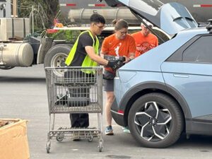 Staff helping upload electronics from a participant's car.